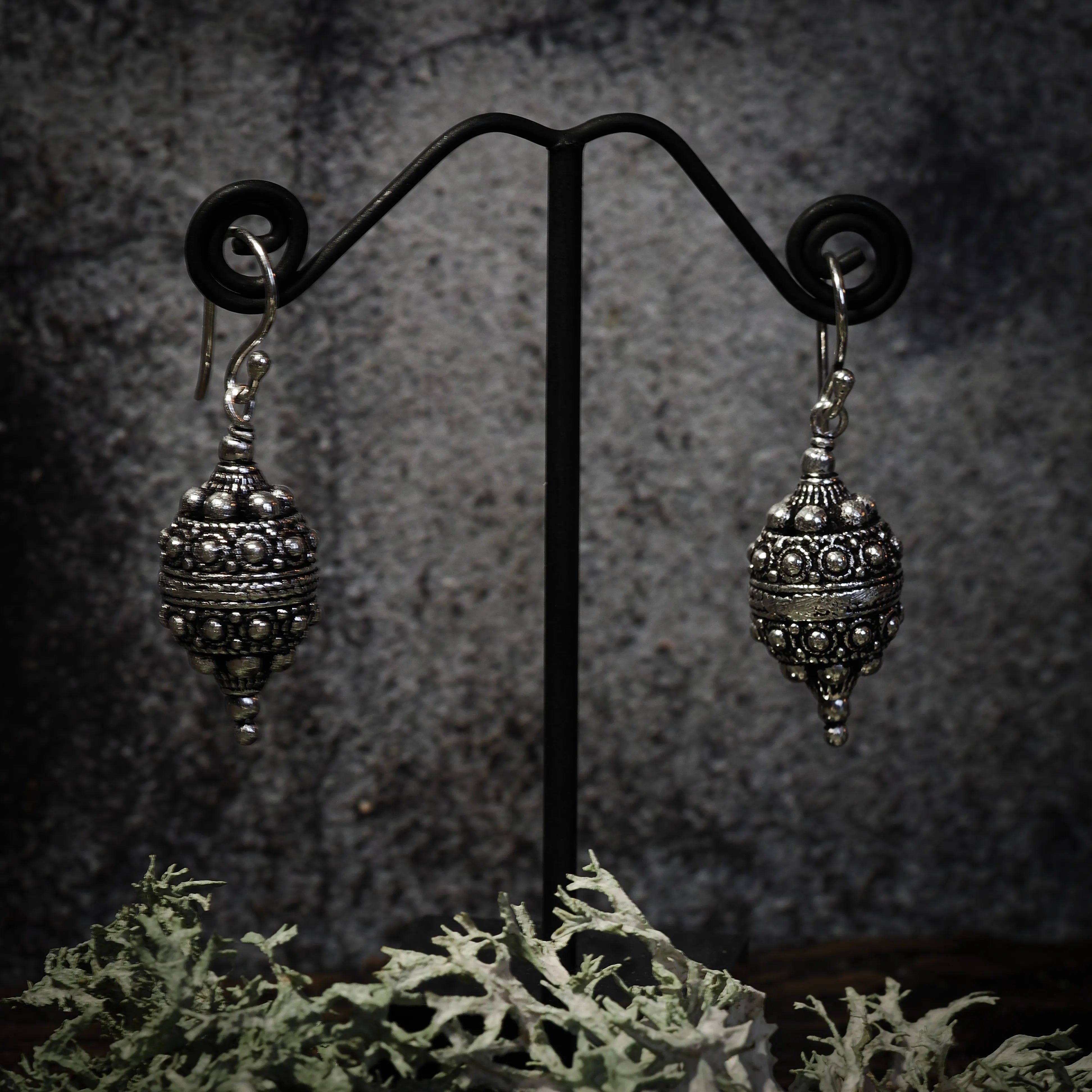 Örhänge Filligran, örhängen visade på mörk bakgrund. Arbetet är detaljerat.