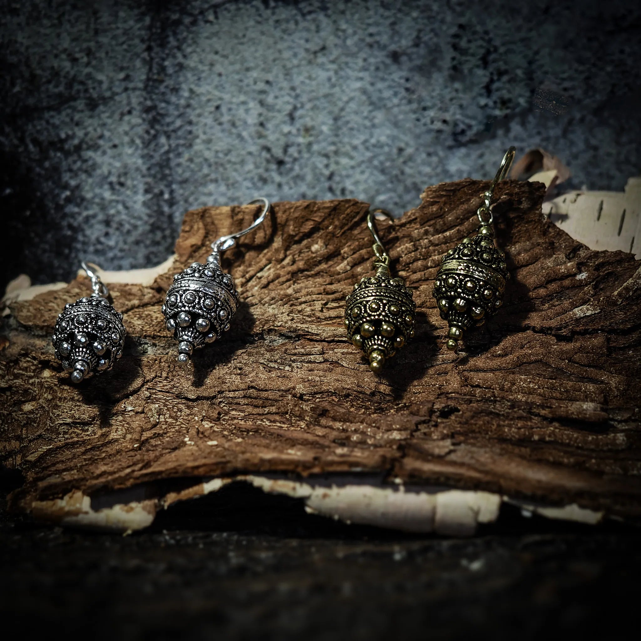 Örhänge Filligran, örhängen visade på mörk bakgrund. Arbetet är detaljerat.