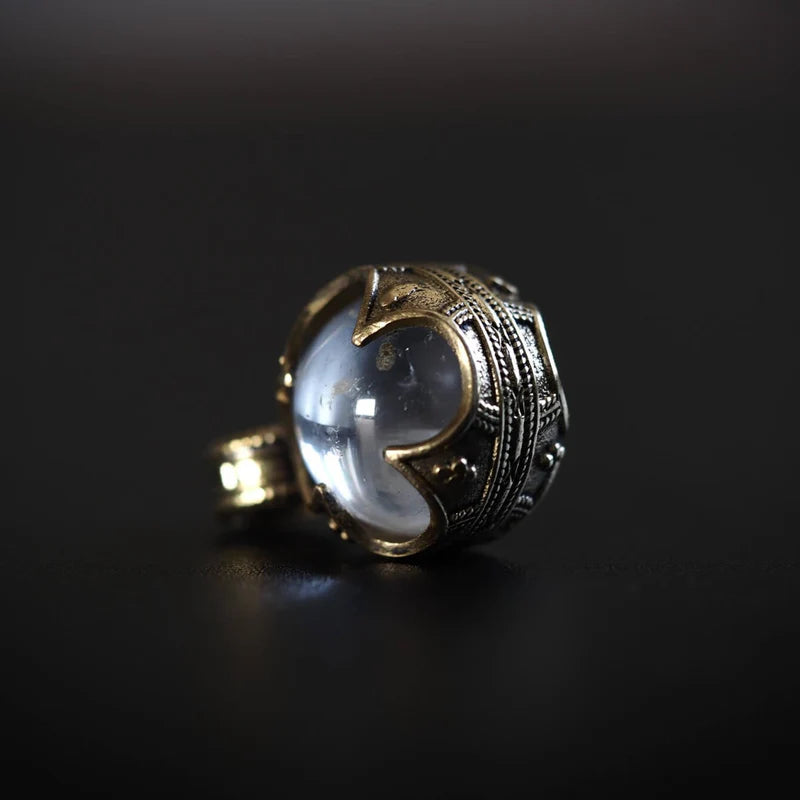 Gotlandshänge i guldfärgad mässing med bergkristall, sidovy mot svart bakgrund