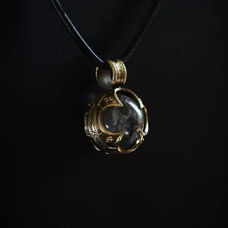 Guldfärgat gotlandshänge med rökig bergkristall, närbild i svart lädersnöre