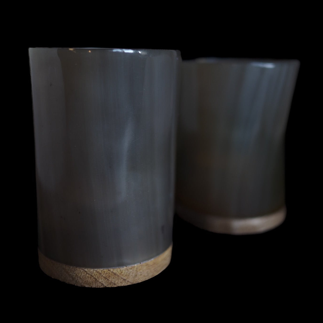 Två hornljuslyktor utan tänd ljus, visar tydligt den regelbundna mönstringen av hjärtformade hål i organiskt horn. Naturliga kornstrukturer och varma bruntoner synliga.